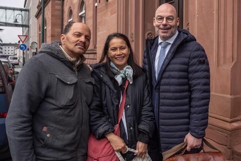 Oithip Möller (Mitte) kommt erleichtert mit ihrem Partner Ange Julien Koutenay-Chrisnerard (links) und ihrem Anwalt Gerret Höher (rechts) aus dem Darmstädter Landgericht. Sie hatte ungebetene Bewohner in ihrem Haus.