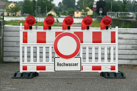 In der Nähe des Rheinpegel Maxau steht eine Barriere auf der ein Schild mit der Aufschrift Hochwasser angebracht ist.  Foto: dpa