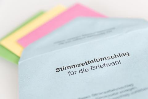 Verschiedene Stimmzettel stecken in einem Stimmzettelumschlag für die Briefwahl.  Foto: Friso Gentsch/dpa