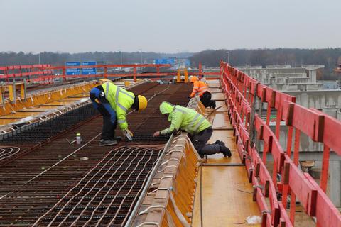 Unweit des Frankfurter Kreuzes bereiten Arbeiter 17 Meter über dem Boden ein Stück Fahrweg der neuen Flughafen-Hochbahn für die Betonierung vor. Foto: Daniel Baczyk