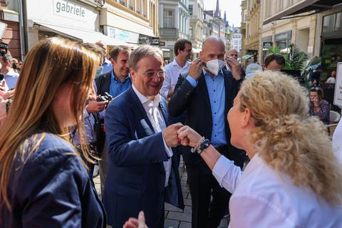 Faust zum Gruß: Armin Laschet mit Renate Schulz-Winkel vor ihrem Café Maldaner. Den CDU-Kanzlerkandidaten begleiten der Bundestagsabgeordnete und Wahlkreiskandidat Ingmar Jung (mit Maske), Landtagsabgeordnete Astrid Wallmann (links) und Kultusminister Alexander Lorz (hinten).  Foto: René Vigneron