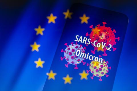 Der Schriftzug der neu entdeckten Virusvariante "SARS-CoV-2 Omicron" auf einem Smartphone und eine visuelle Darstellung des Virus vor dem Hintergrund einer Flagge der Europäischen Union. Foto: dpa