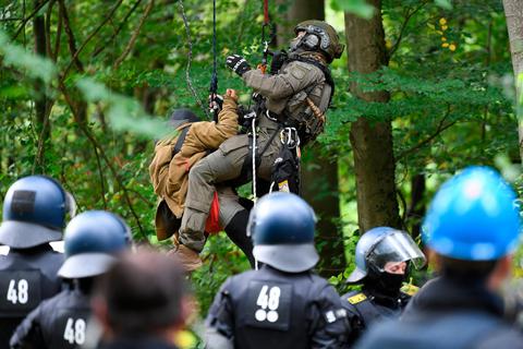 Ein Beamter des Spezialeinsatzkommandos (SEK) hat eine Aktivistin im Maulbacher Wald von einem Baum abgeseilt. Symbolfoto: Arne Dedert/dpa 