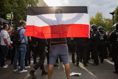 Ein Mann hält eine Reichsflagge bei einem Protest gegen die Corona-Maßnahmen. Foto: dpa