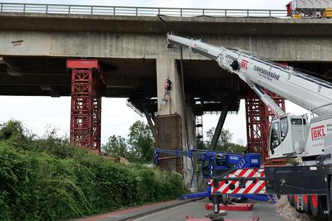 Mit einem Kran wird ein Gitterkorsett am Pfeiler der Salzbachtalbrücke angebracht, das dann mit Spritzbeton ummantelt wird. Foto: Autobahn GmbH