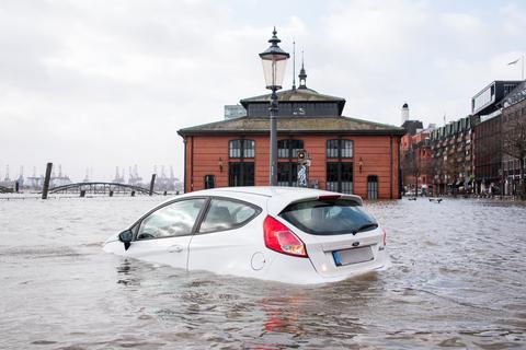 Ein Auto steht auf dem Hamburger Fischmarkt während einer Sturmflut im Wasser der Elbe.  Foto: dpa