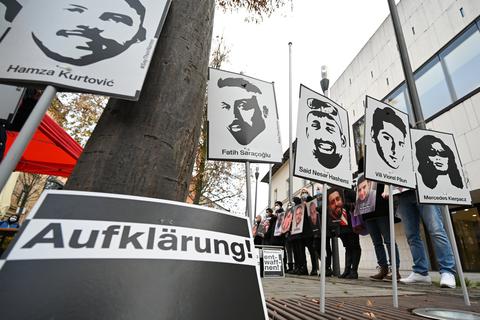 Angehörige der Opfer des rassistischen Anschlags von Hanau 2020 halten bei einer Mahnwache vor dem hessischen Landtag Fotos der Opfer.  Foto: dpa