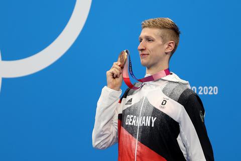 Florian Wellbrock aus Deutschland mit Bronzemedaille bei der Siegerehrung.  Foto: Oliver Weiken/dpa